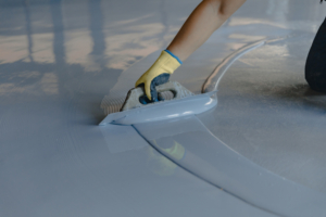 The,Worker,Applies,Gray,Epoxy,Resin,To,The,New,Floor